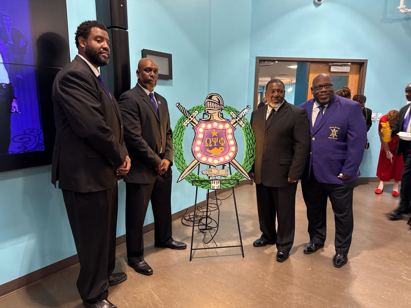 Alpha Iota brothers with the Omega Psi Phi crest