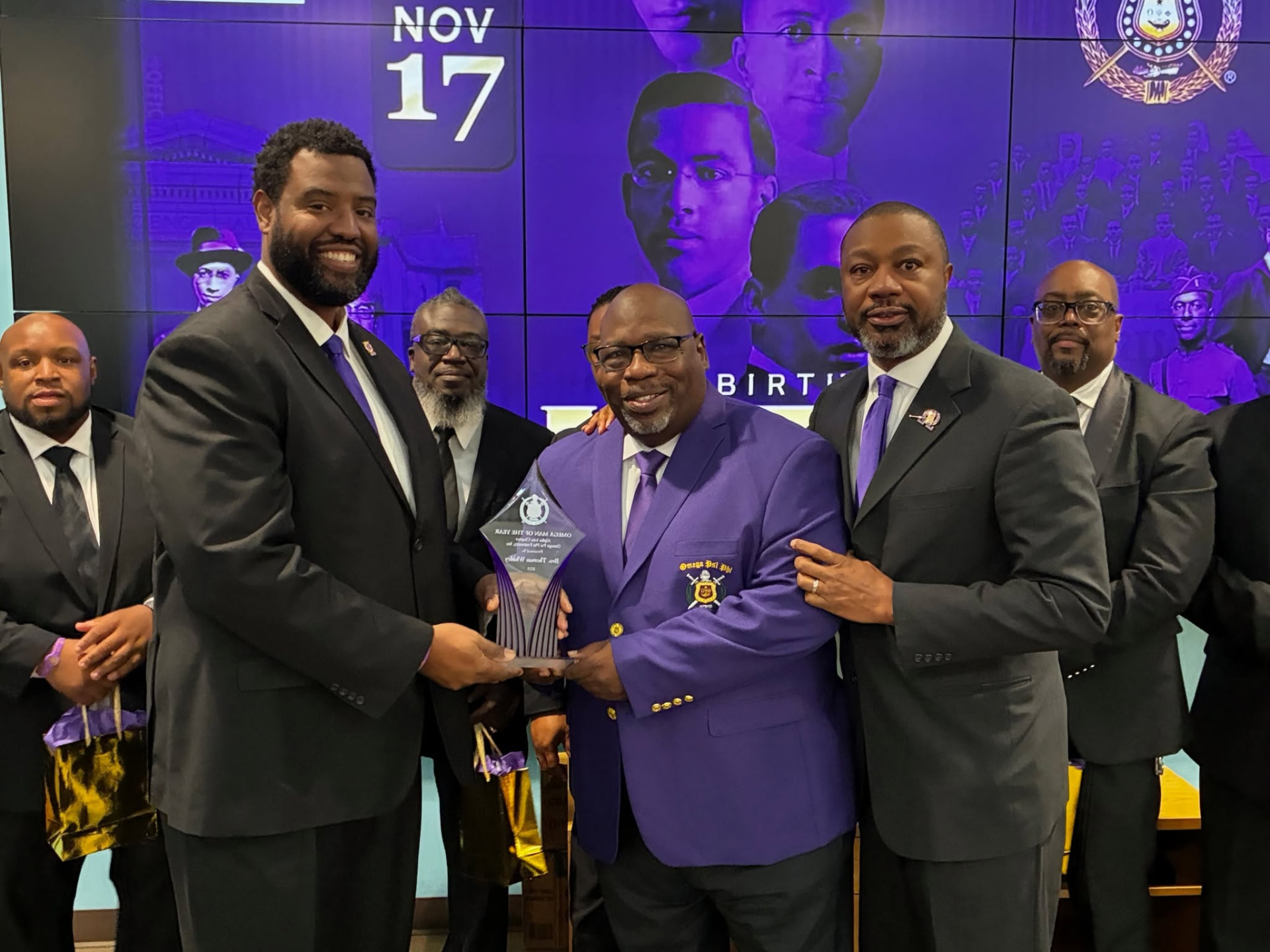 Alpha Iota brothers presenting an Achievement Week honor